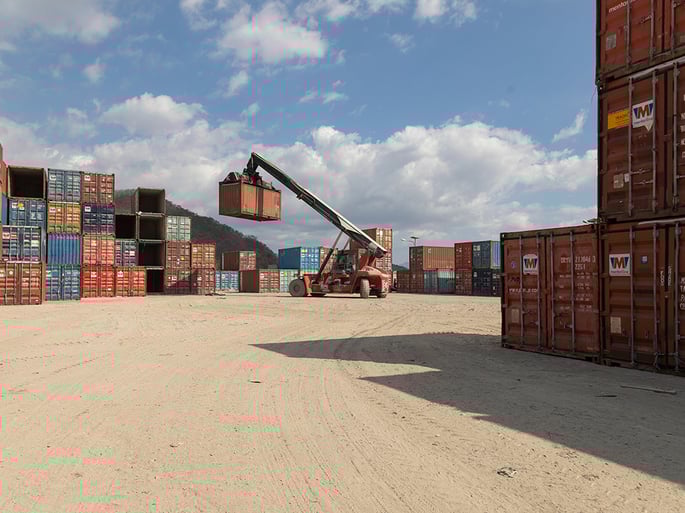 Contenedor dry van cargado en un puerto marítimo, listo para su transporte.